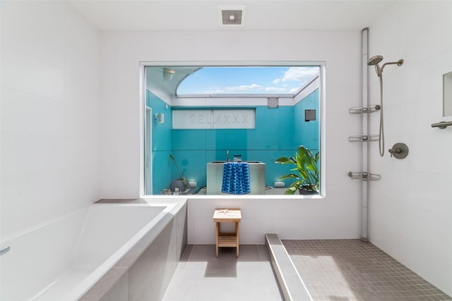 bathroom with visible vents, a tile shower, tile walls, and a bath