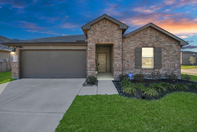 ranch-style home featuring driveway, brick siding, an attached garage, and a front yard