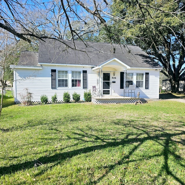 single story home with covered porch and a front yard