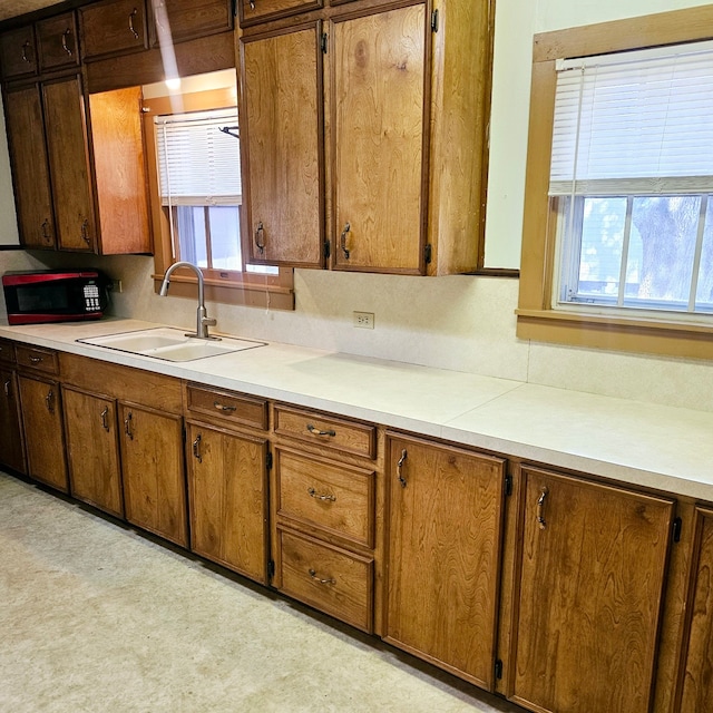 kitchen with brown cabinets, light countertops, and a sink