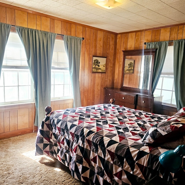 carpeted bedroom featuring wooden walls