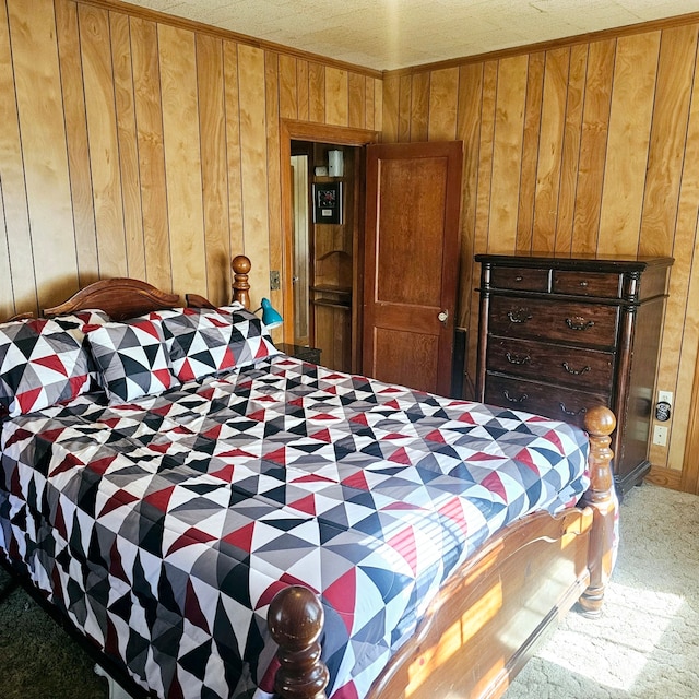 bedroom featuring crown molding, carpet floors, and wooden walls