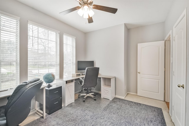 office space featuring baseboards and a ceiling fan