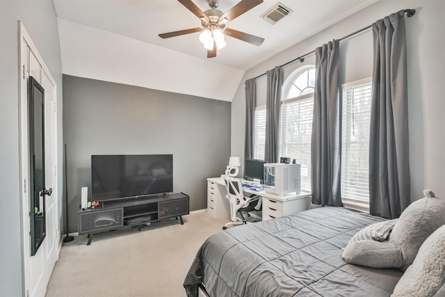 bedroom featuring light carpet, vaulted ceiling, visible vents, and a ceiling fan