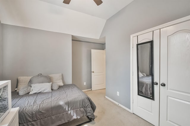 bedroom with a ceiling fan, light colored carpet, vaulted ceiling, and baseboards