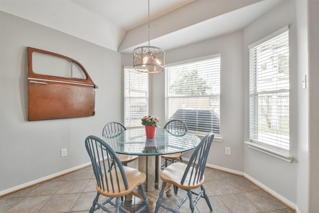 dining area with a chandelier, vaulted ceiling, baseboards, and tile patterned floors