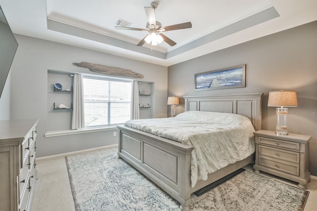 bedroom with a tray ceiling, visible vents, and baseboards