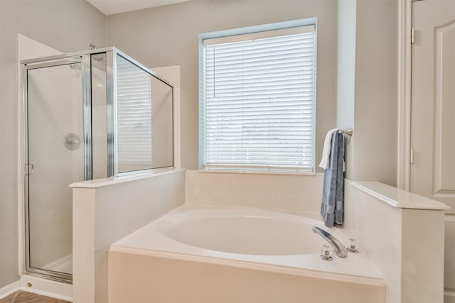 bathroom featuring a stall shower and a bath