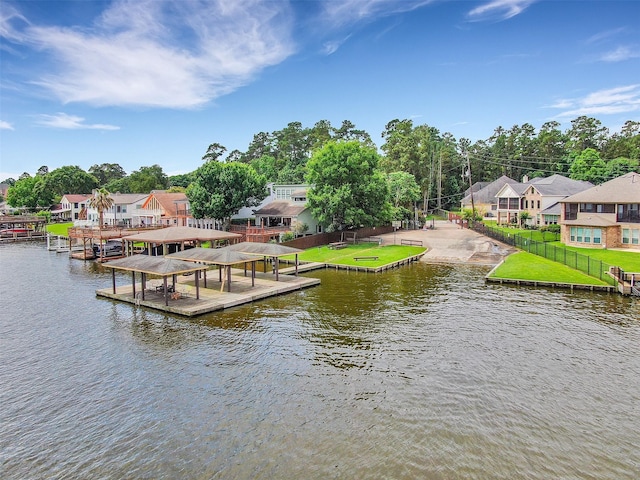 dock area featuring a yard, a water view, fence, and a residential view