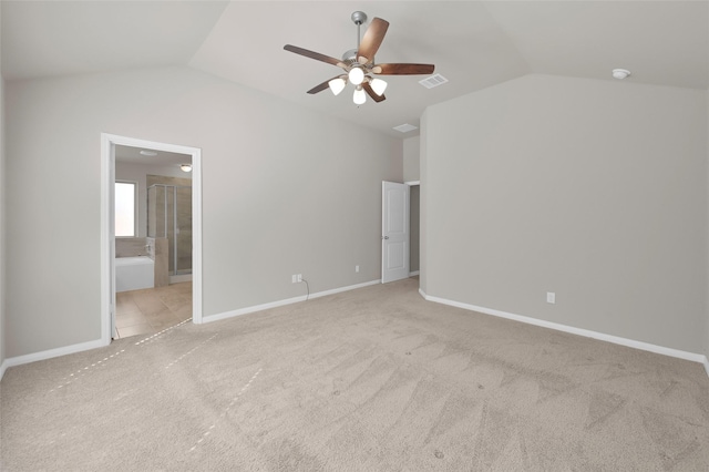 carpeted empty room featuring baseboards, visible vents, vaulted ceiling, and a ceiling fan