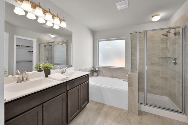 bathroom with double vanity, a stall shower, a garden tub, a walk in closet, and a sink