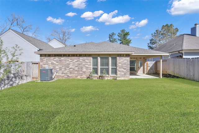 back of property featuring a yard, a patio, central AC, and brick siding