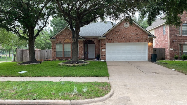 view of front of property with an attached garage, driveway, fence, and brick siding