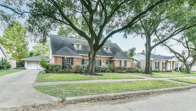 view of front of home featuring a garage, a shingled roof, a front lawn, and brick siding