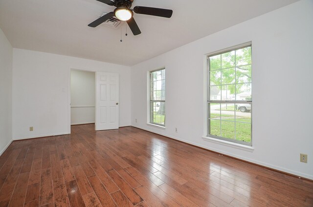 empty room featuring baseboards, visible vents, wood finished floors, and ceiling fan