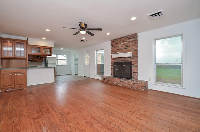 unfurnished living room featuring visible vents, a fireplace, ceiling fan, wood finished floors, and recessed lighting