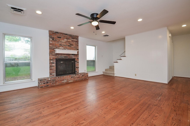 unfurnished living room with wood finished floors, recessed lighting, stairs, and visible vents