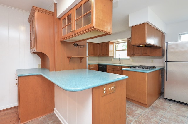 kitchen with glass insert cabinets, decorative backsplash, appliances with stainless steel finishes, and a peninsula