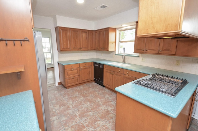 kitchen featuring decorative backsplash, a sink, visible vents, dishwasher, and brown cabinets