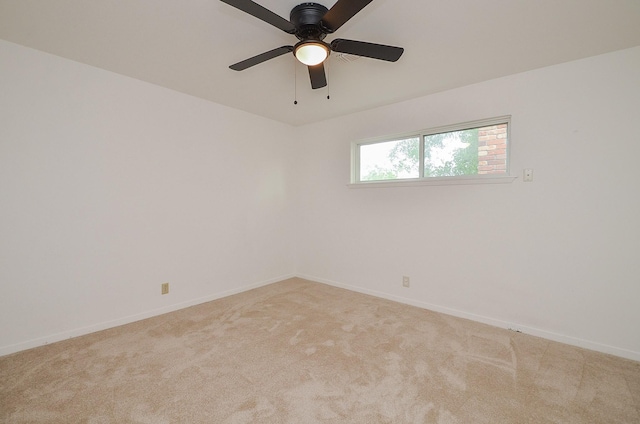 spare room featuring baseboards, ceiling fan, and light carpet
