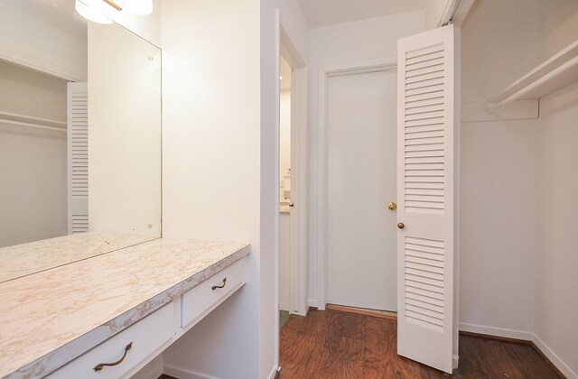 bathroom with baseboards, wood finished floors, and vanity