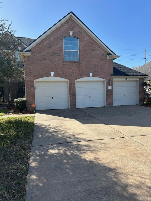 view of front of property with a garage, brick siding, and driveway