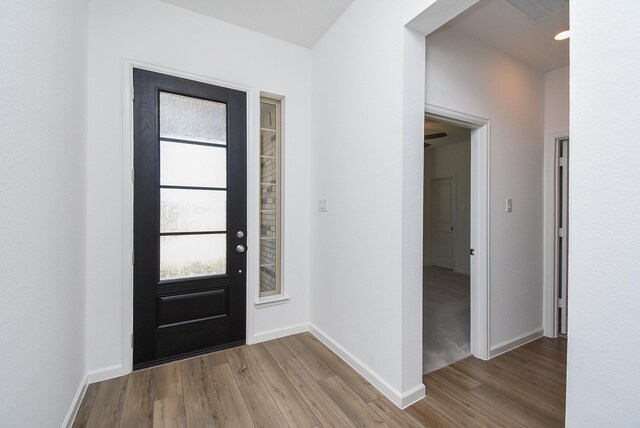 foyer featuring wood finished floors and baseboards