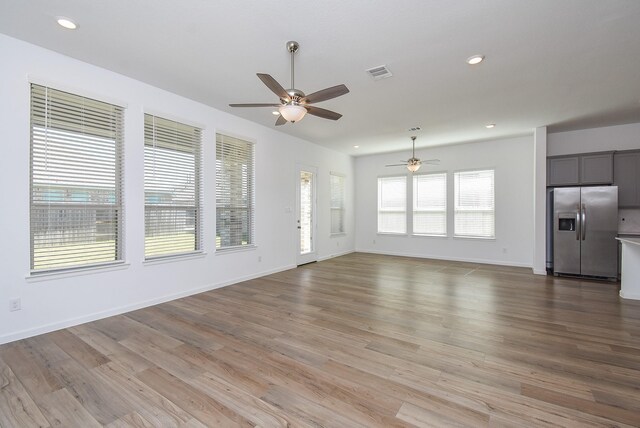 unfurnished living room with visible vents, recessed lighting, light wood-type flooring, and baseboards