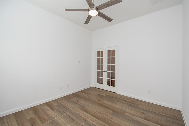 spare room with french doors, baseboards, wood finished floors, and a ceiling fan