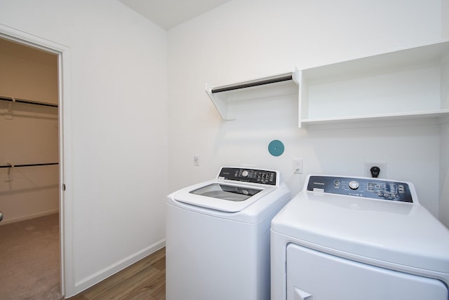 laundry room featuring laundry area, wood finished floors, baseboards, and independent washer and dryer