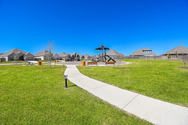 surrounding community featuring fence, playground community, a residential view, and a lawn