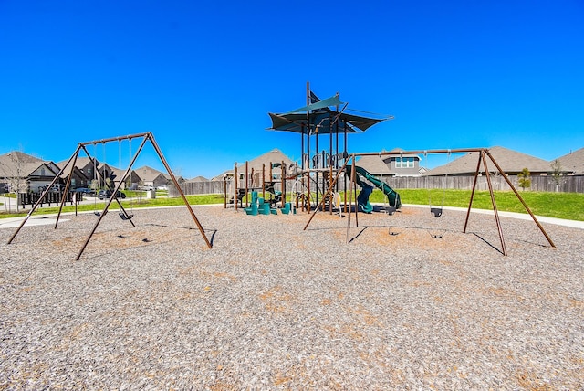 community playground with a residential view and fence