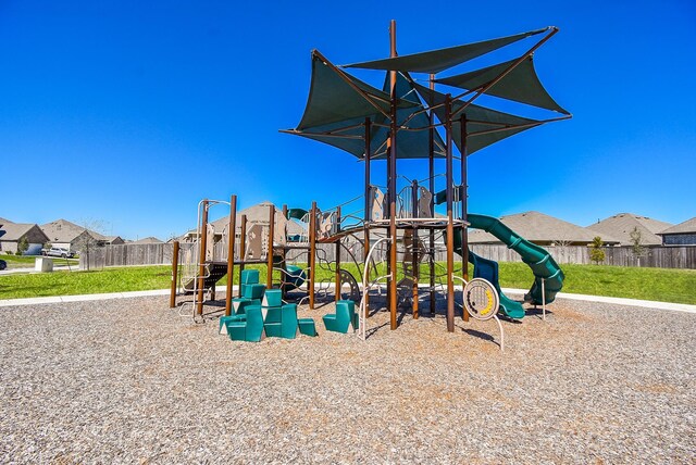 community playground with a residential view and fence