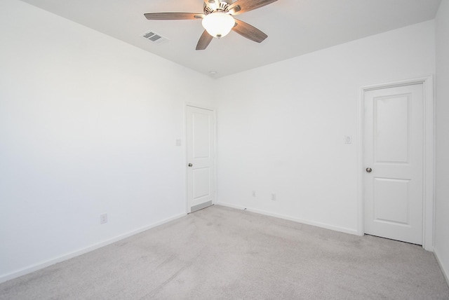 unfurnished room with baseboards, a ceiling fan, visible vents, and light carpet