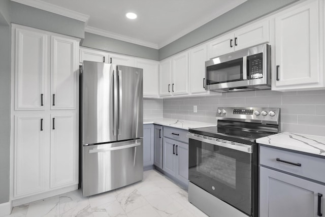 kitchen featuring marble finish floor, appliances with stainless steel finishes, light stone counters, and crown molding