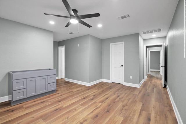 spare room with light wood-style flooring, visible vents, and baseboards