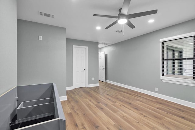 unfurnished room with recessed lighting, wood finished floors, visible vents, and baseboards