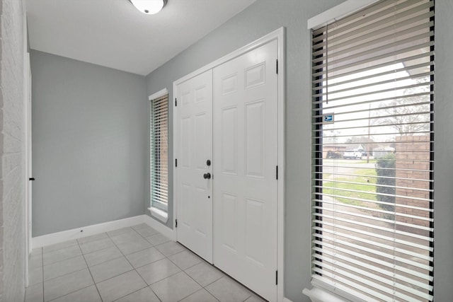 entrance foyer with light tile patterned floors, a wealth of natural light, and baseboards