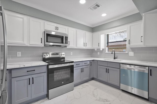 kitchen with gray cabinetry, stainless steel appliances, a sink, visible vents, and marble finish floor