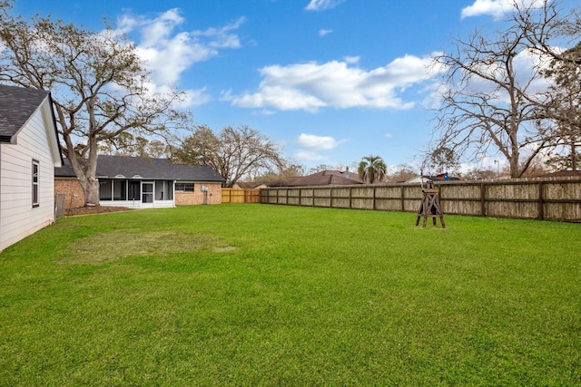 view of yard with a sunroom and a fenced backyard