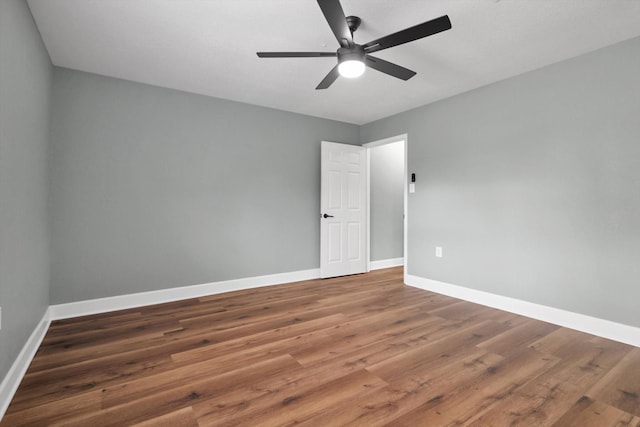 spare room featuring a ceiling fan, baseboards, and wood finished floors