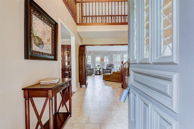 interior space featuring light tile patterned floors and a towering ceiling