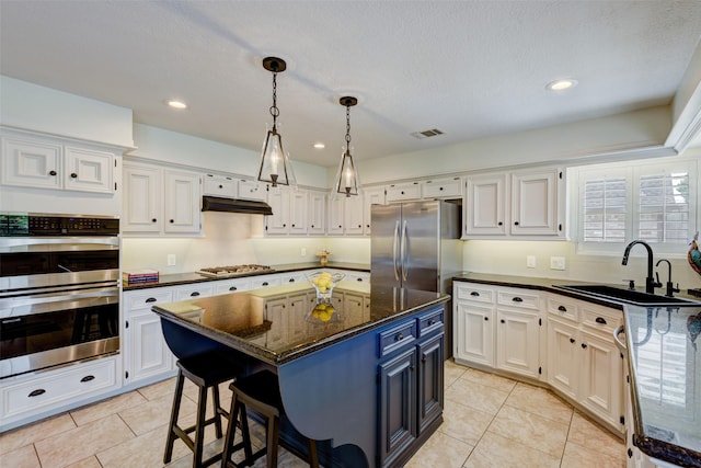 kitchen with white cabinets, under cabinet range hood, visible vents, and stainless steel appliances