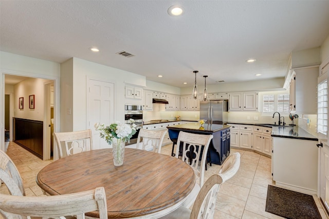 dining area with light tile patterned floors, a textured ceiling, visible vents, and recessed lighting