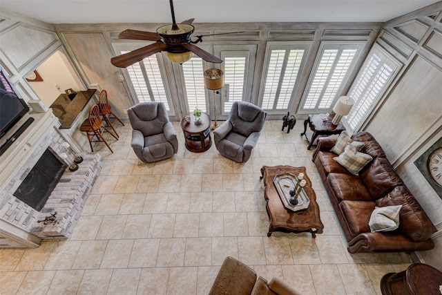 tiled living room with a brick fireplace and a ceiling fan