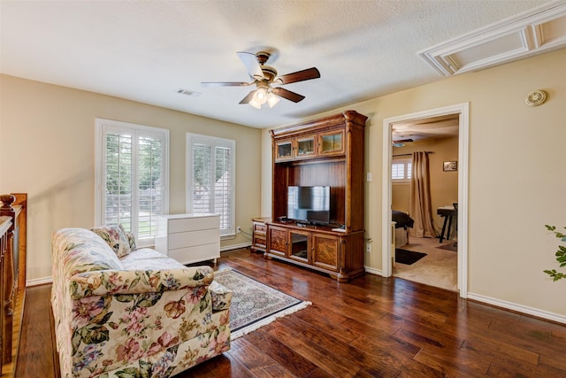 sitting room featuring ceiling fan, a textured ceiling, visible vents, baseboards, and dark wood finished floors