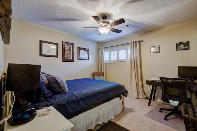 carpeted bedroom featuring a ceiling fan, visible vents, and a textured ceiling