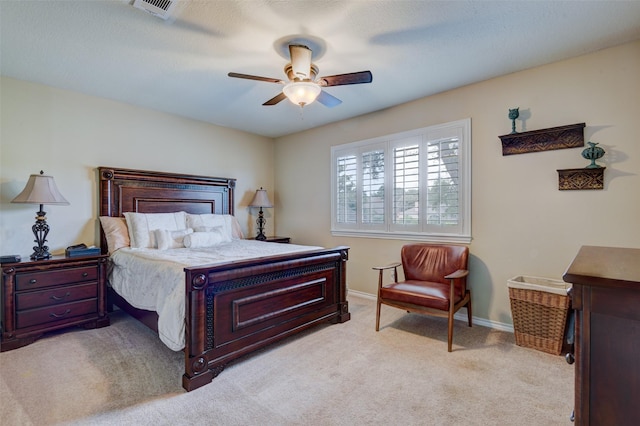 bedroom with a ceiling fan, light carpet, visible vents, and baseboards