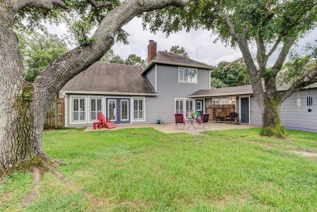 rear view of property with a patio area, a chimney, fence, and french doors