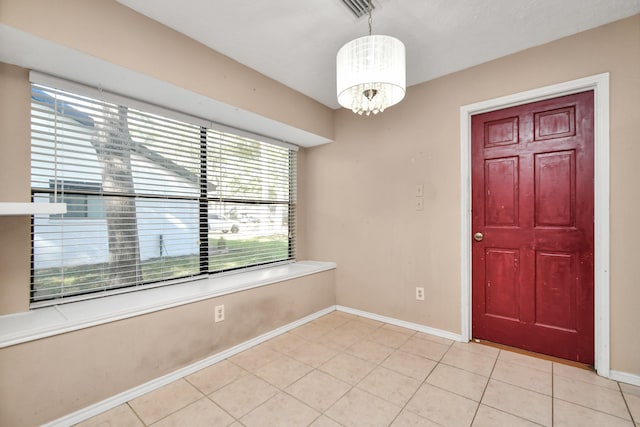 interior space with baseboards, light tile patterned floors, and an inviting chandelier